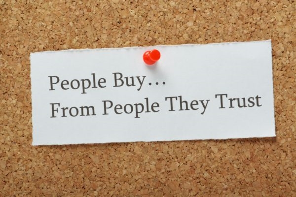 A note pinned on a cork board that says  and quot;People Buy...From People They Trust. and quot;